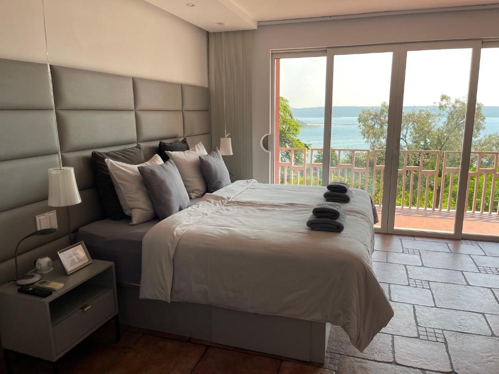 um quarto com uma cama grande e uma janela grande em Villa Bellavista II em Portorož