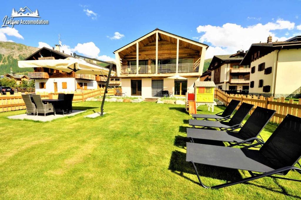 a group of chairs sitting in the yard of a house at Radici Relais Sulle Piste da sci vicino a Lupigno in Livigno