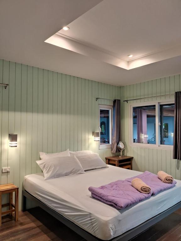 a bedroom with a large bed with two towels on it at Rabbit House in Ban Han Tra Fang Nua