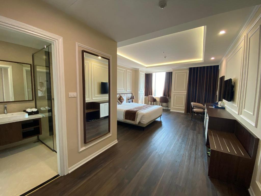 Phủ LýにあるRiverside Hotel Hà Namのベッドとバスルーム付きのホテルルームです。