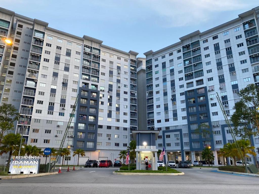 un gran edificio de apartamentos con un reloj delante en YAYA HOMESTAY CYBERJAYA & PUTRAJAYA en Cyberjaya