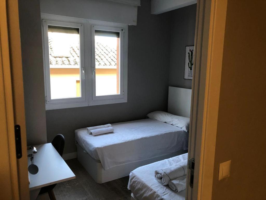 a small room with two beds and a window at Habitación Doble - Apartamento in Estella
