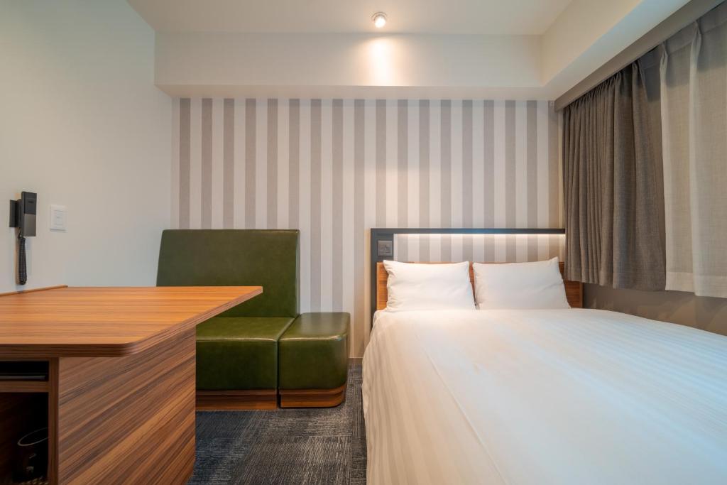 Postel nebo postele na pokoji v ubytování Via Inn Prime Osaka Kyobashi