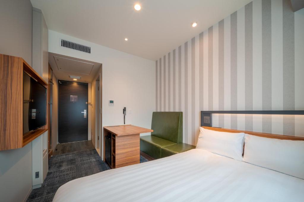 Postel nebo postele na pokoji v ubytování Via Inn Prime Osaka Kyobashi