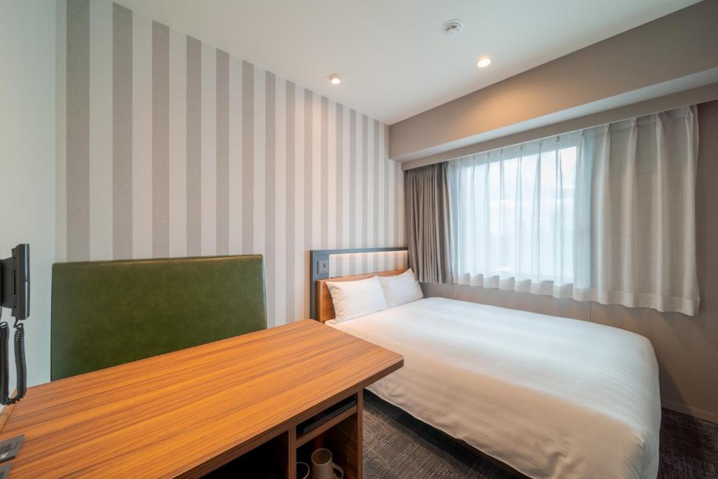 Postel nebo postele na pokoji v ubytování Via Inn Prime Osaka Kyobashi