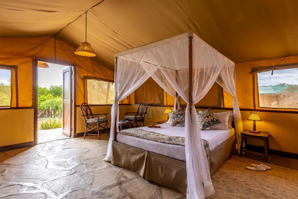 una camera con letto a baldacchino in una tenda. di Sentrim Tsavo Lodge a Tsavo