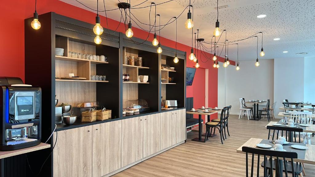 a restaurant with a bar with tables and chairs at Nemea Appart Hotel Coliseum Amiens Centre in Amiens