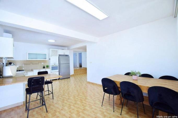 cocina con mesa y sillas en una habitación en וילת אבן ספיר, en Gefen