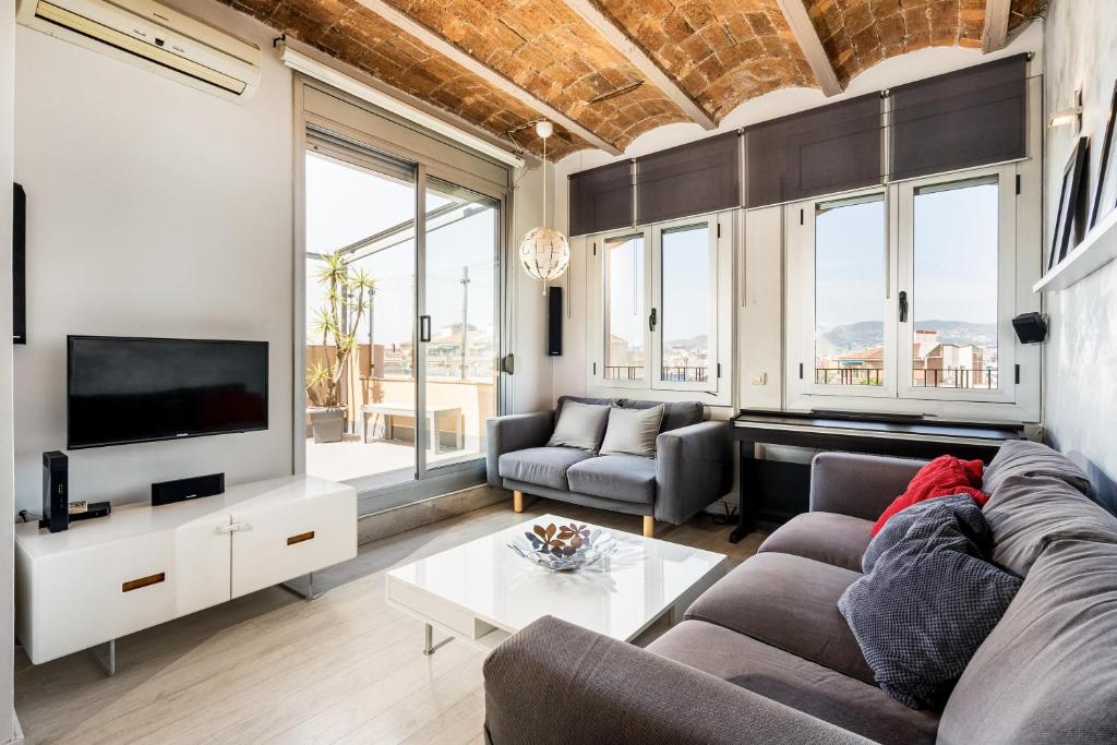 a living room with a couch and a tv at Stunning 2-bedroom Apartment With Two Terraces in Barcelona