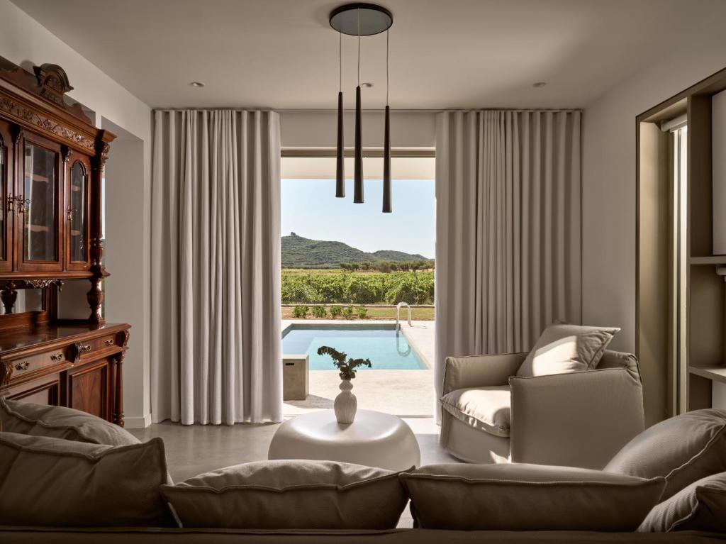 uma sala de estar com um sofá, uma mesa e uma piscina em Azera Suites em Alikanás