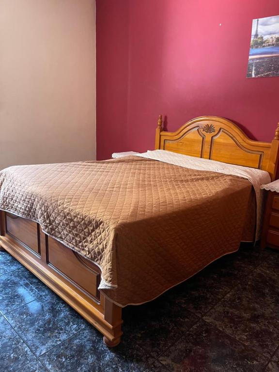 a bed in a bedroom with a red wall at Аппартаменты Эль Эхидо in El Ejido