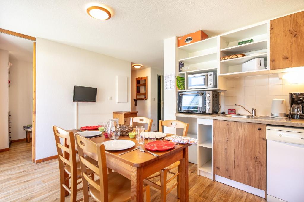 a kitchen and dining room with a table and chairs at Le Silène - Appt pour 6 in Chamrousse