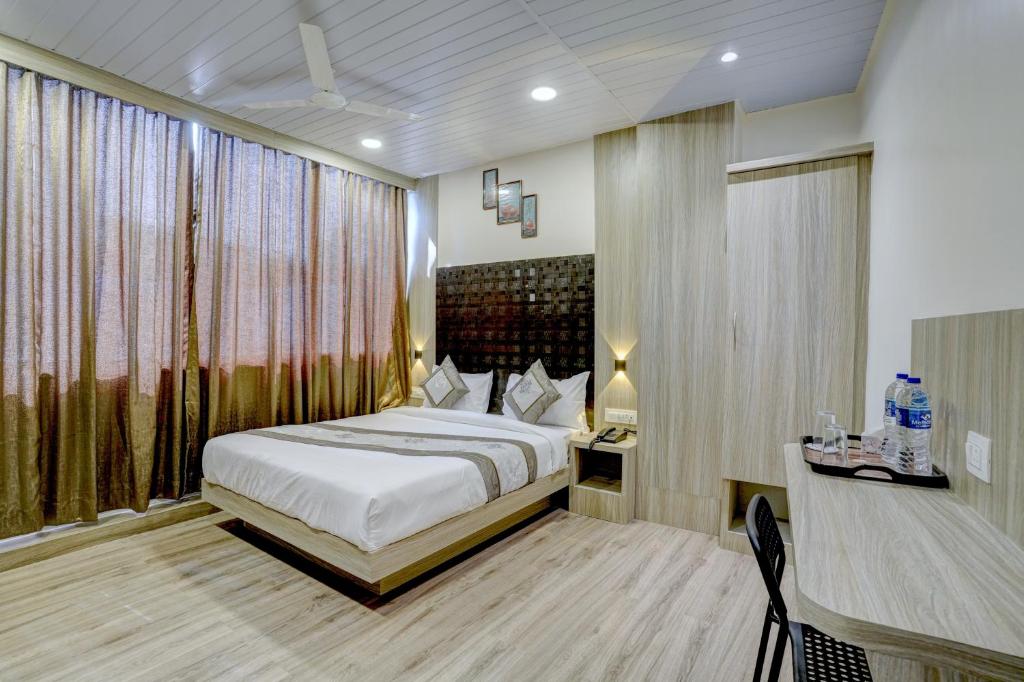 a bedroom with a bed and a desk in a room at Hotel Arts International in Mumbai