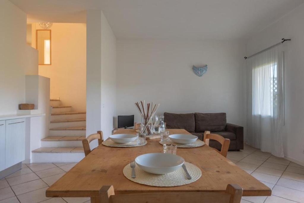 tavolo da pranzo con ciotole e piatti di Elegant Residence Ea Bianca 2 Bedroom sleeps 6 extra bed available n0614 a Cala Bitta