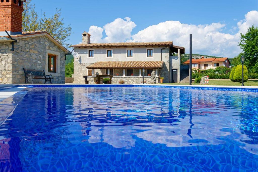 una gran piscina azul frente a una casa en Holiday Home Eda, en Buzet