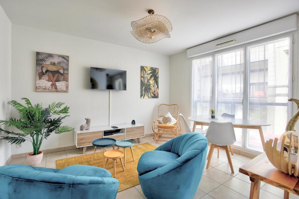 un salon avec des chaises bleues et une table dans l'établissement Expédition Malouine - Appt à 30m de la plage, à Saint-Malo