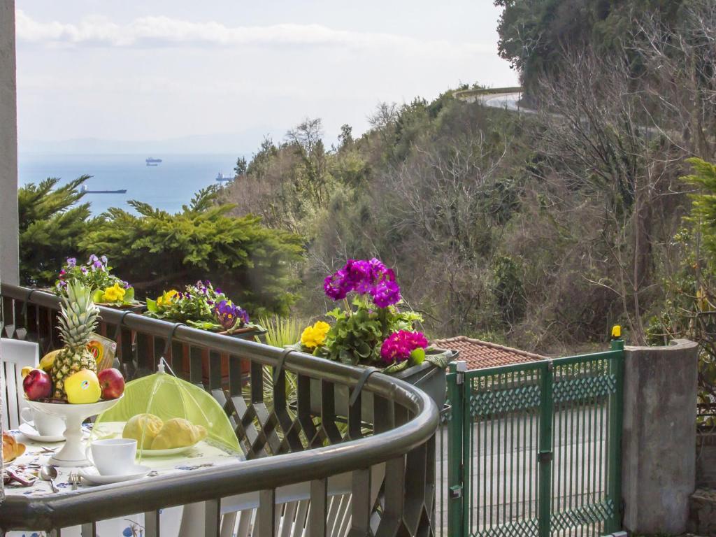 un balcón con una mesa con comida y flores. en Villa Fontana Limite, en Vietri