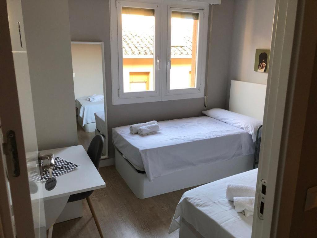 mały pokój z 2 łóżkami i oknem w obiekcie Habitación Doble en el centro - Apartamento w mieście Estella