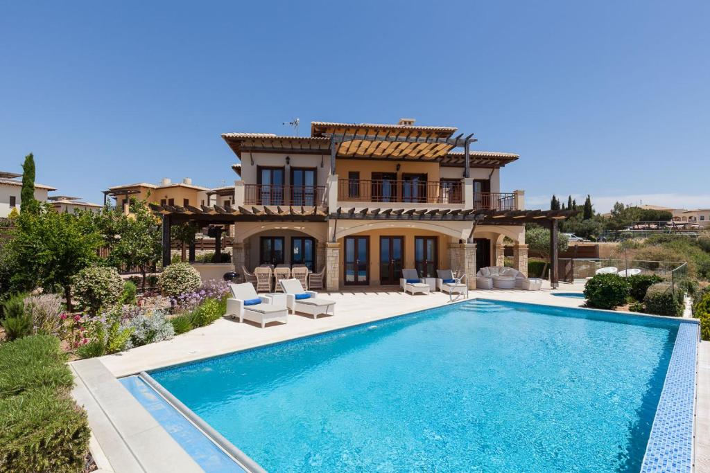 eine Villa mit einem Pool vor einem Haus in der Unterkunft Aphrodite Hills Rentals - Mythos in Kouklia