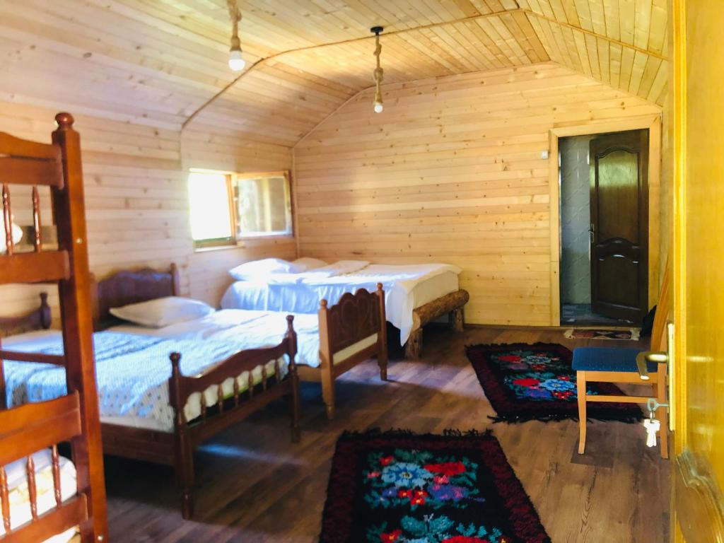 a bedroom with two beds in a wooden cabin at Guest house Hyrmet Demushi in Valbonë