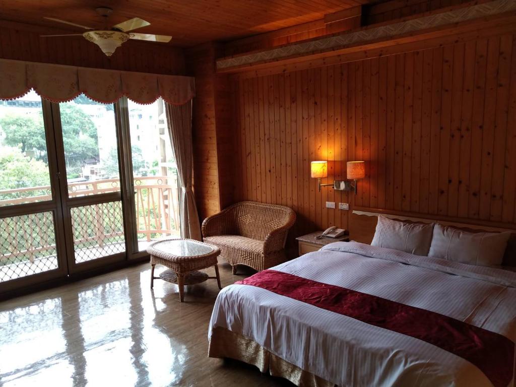1 dormitorio con 1 cama, 1 silla y 1 ventana en Ku Kuan Resort Hotel en Heping