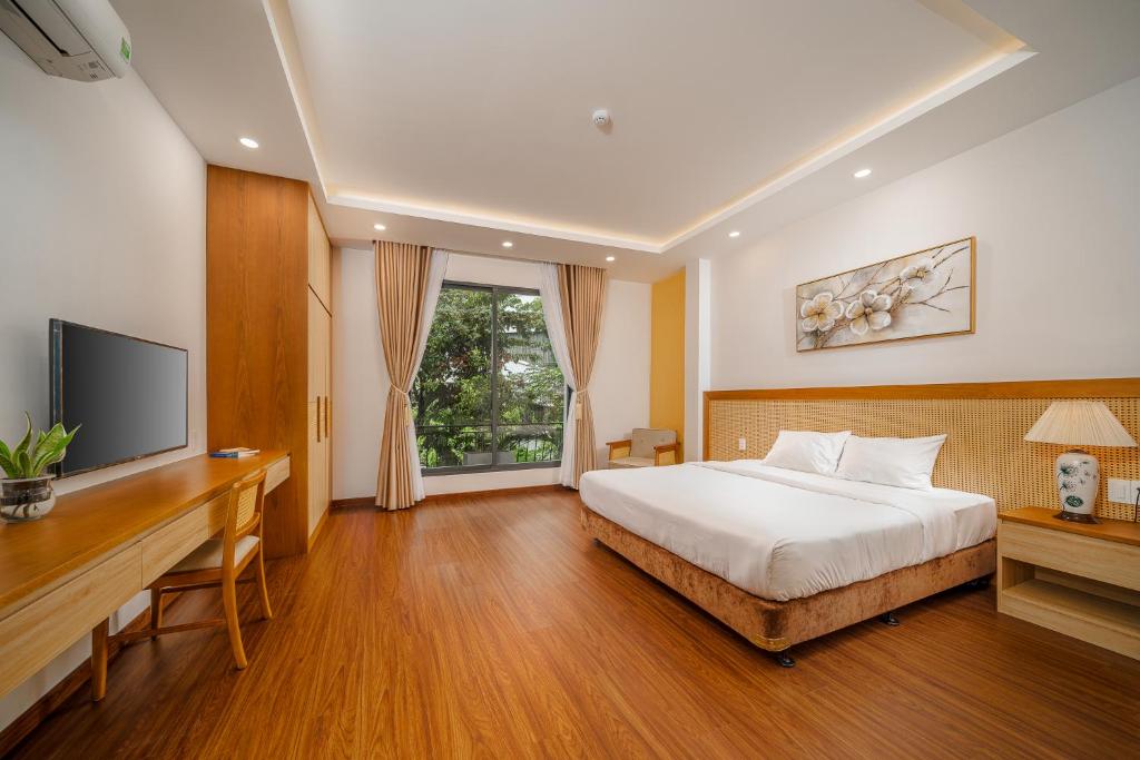 ダナンにあるMay Home Apartment Da Nangのベッドルーム(ベッド1台、デスク、テレビ付)
