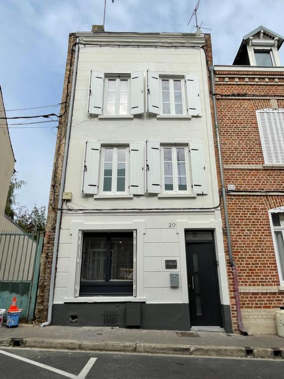 ein weißes Gebäude mit weißen Fensterläden darauf in der Unterkunft L'Annexe Amiens in Amiens