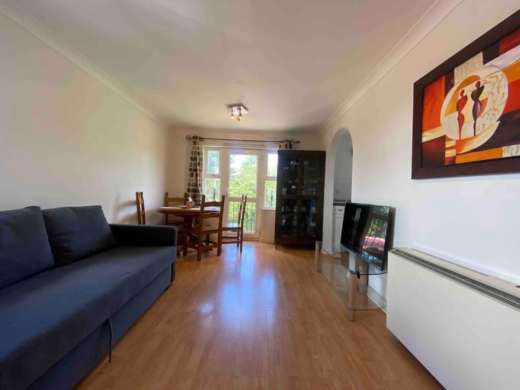 a living room with a blue couch and a tv at cosy one bed Mill hill in Hendon