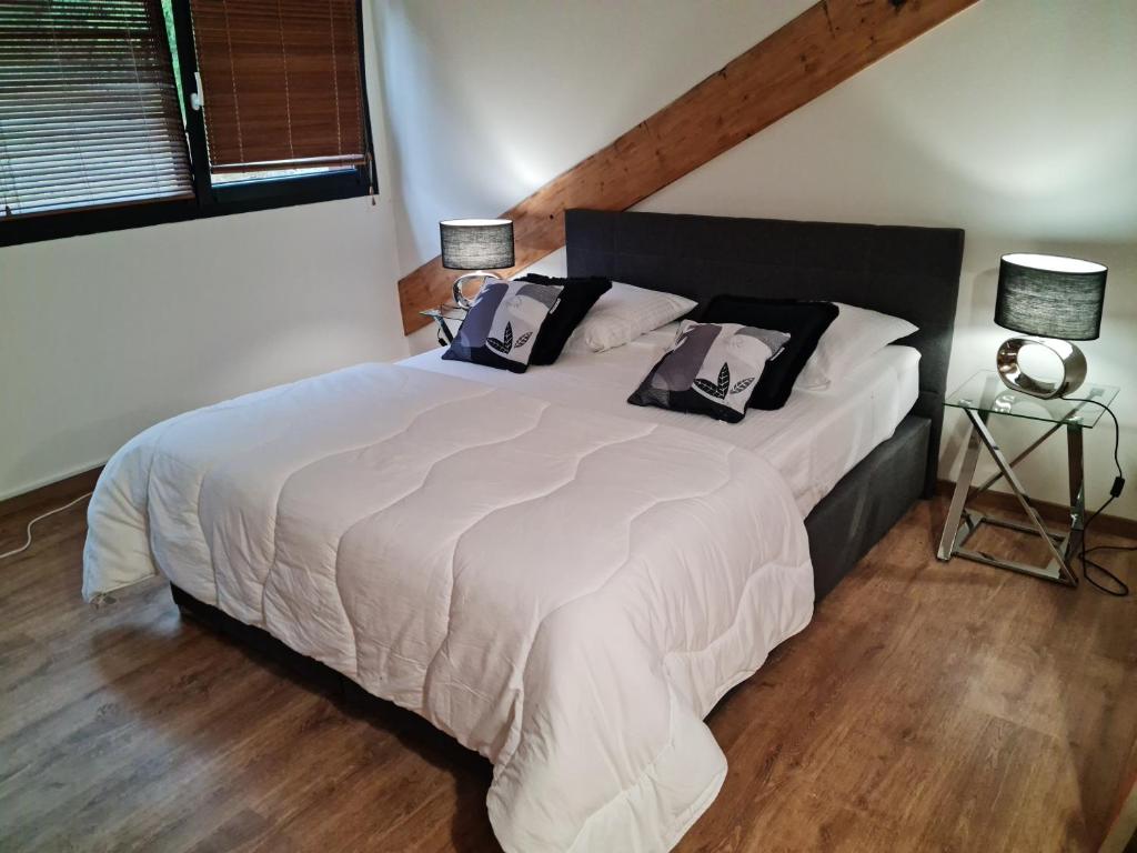 a bedroom with a large white bed with two pillows at La Factory in Porrentruy