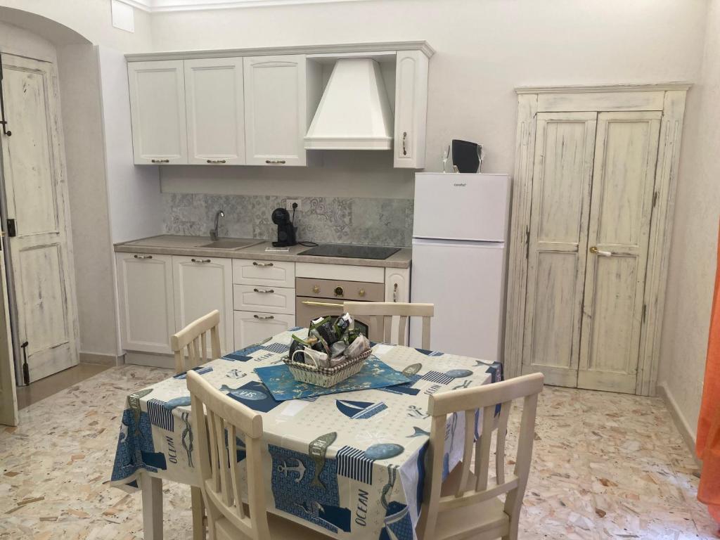 カンポマリーノにあるla casetta del borgoのキッチン(テーブル、白い冷蔵庫付)