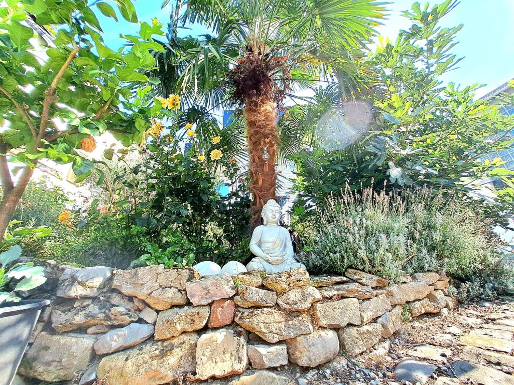 a statue sitting on a stone wall in a garden at Art & Living Apartment in Schoneck