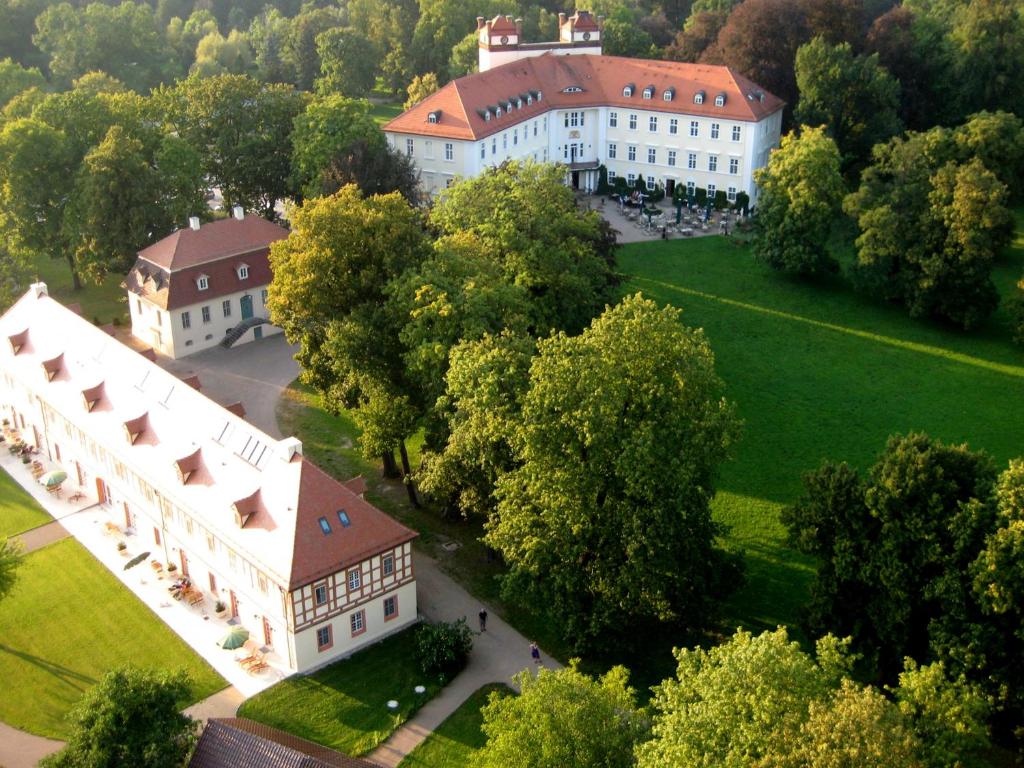 an aerial view of a large white building with trees at Schloss Lübbenau in Lübbenau