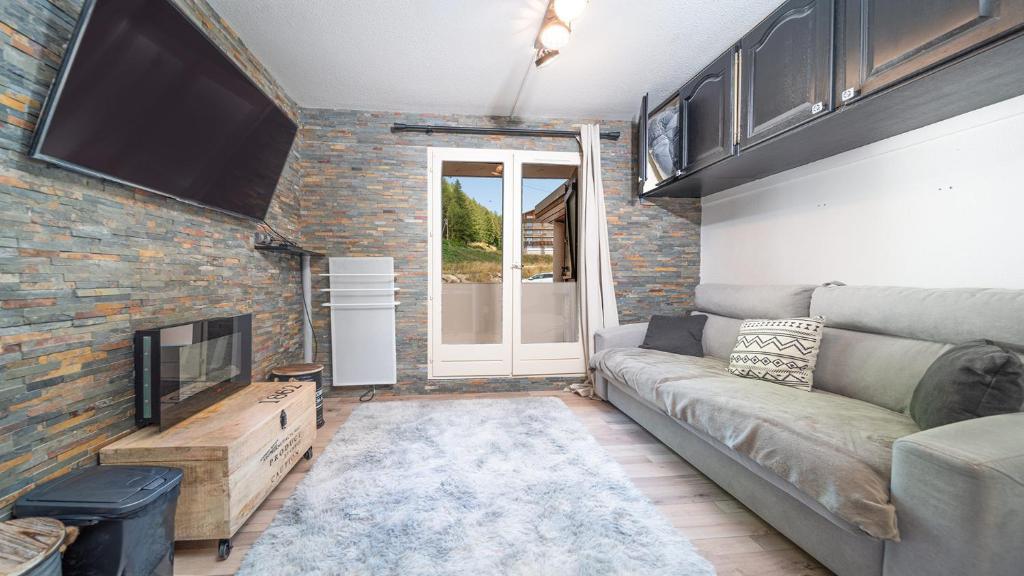 un salon avec un canapé et une télévision dans l'établissement LE SCHUSS 4 - 342 - Studio lumineux 2-4 pers, à La Foux