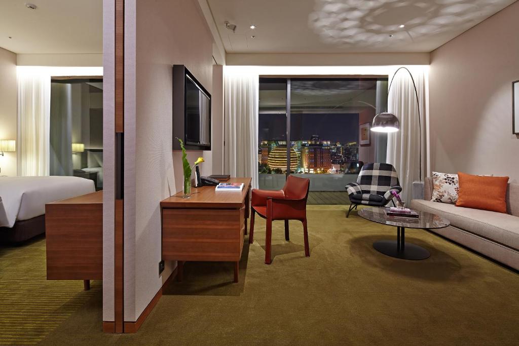 a hotel room with a bed and a couch and a desk at Eslite Hotel in Taipei