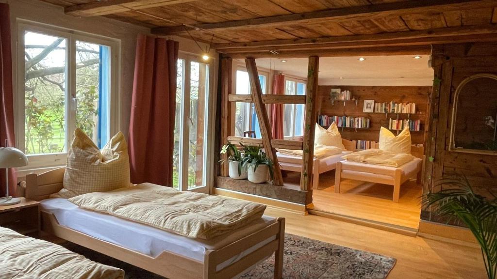a bedroom with two beds and a living room at Gästehaus am Sonnenfeld in Sommeri