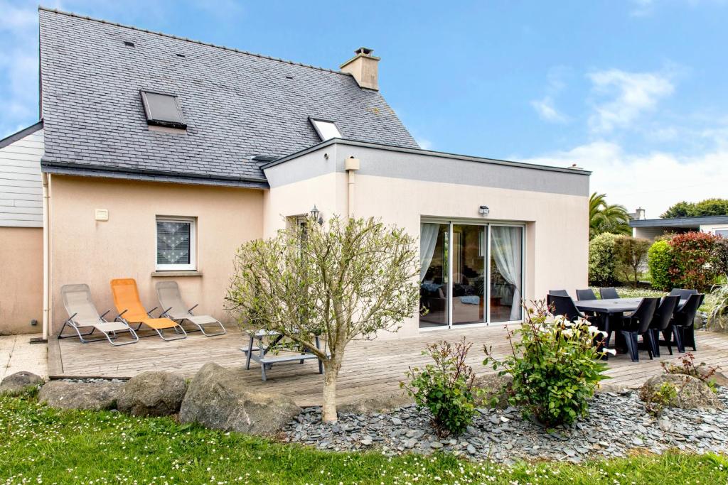 une maison dotée d'une terrasse avec des chaises et une table dans l'établissement L’Albizia … Maison familiale proche des plages, à Plougoulm