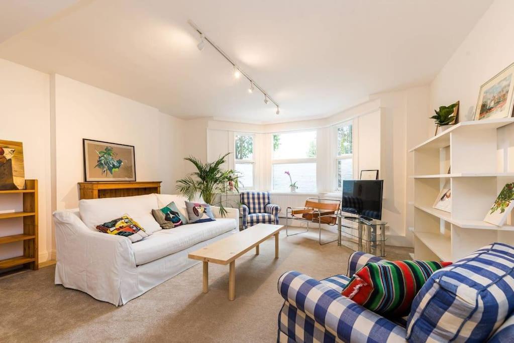 a living room with two couches and a tv at Spacious 2 bed Garden Flat by the Thames+parking in London