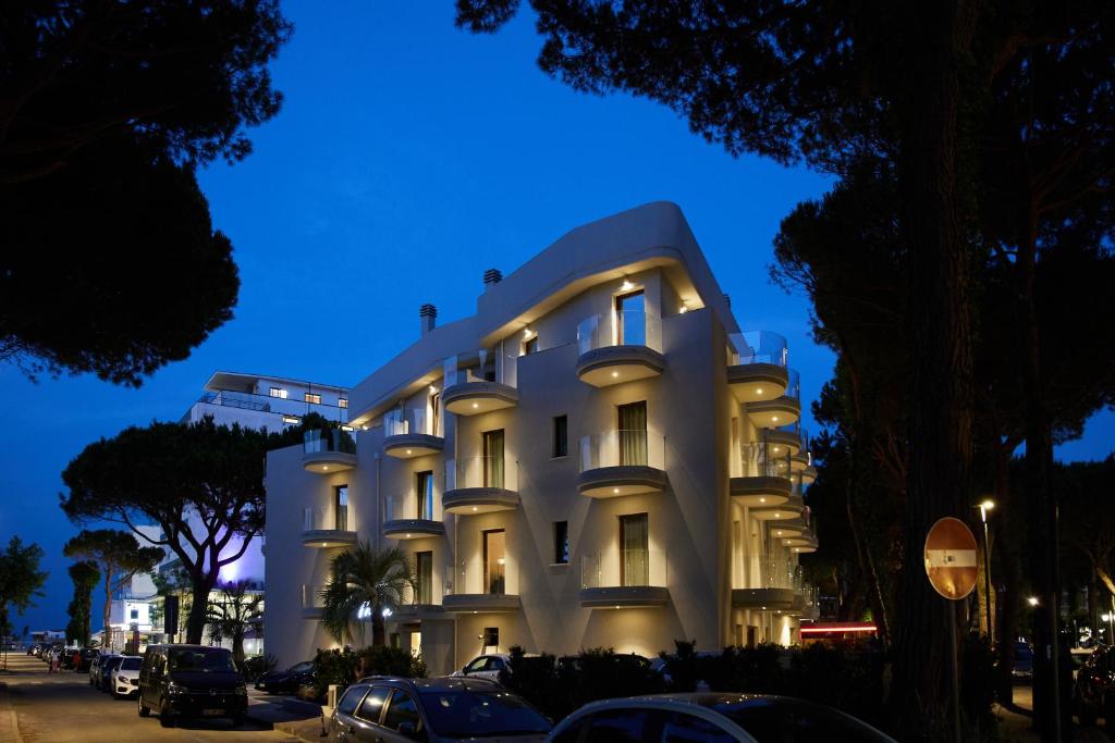 a white building with cars parked in front of it at Mima Aparthotel Boutique & Spa in Milano Marittima