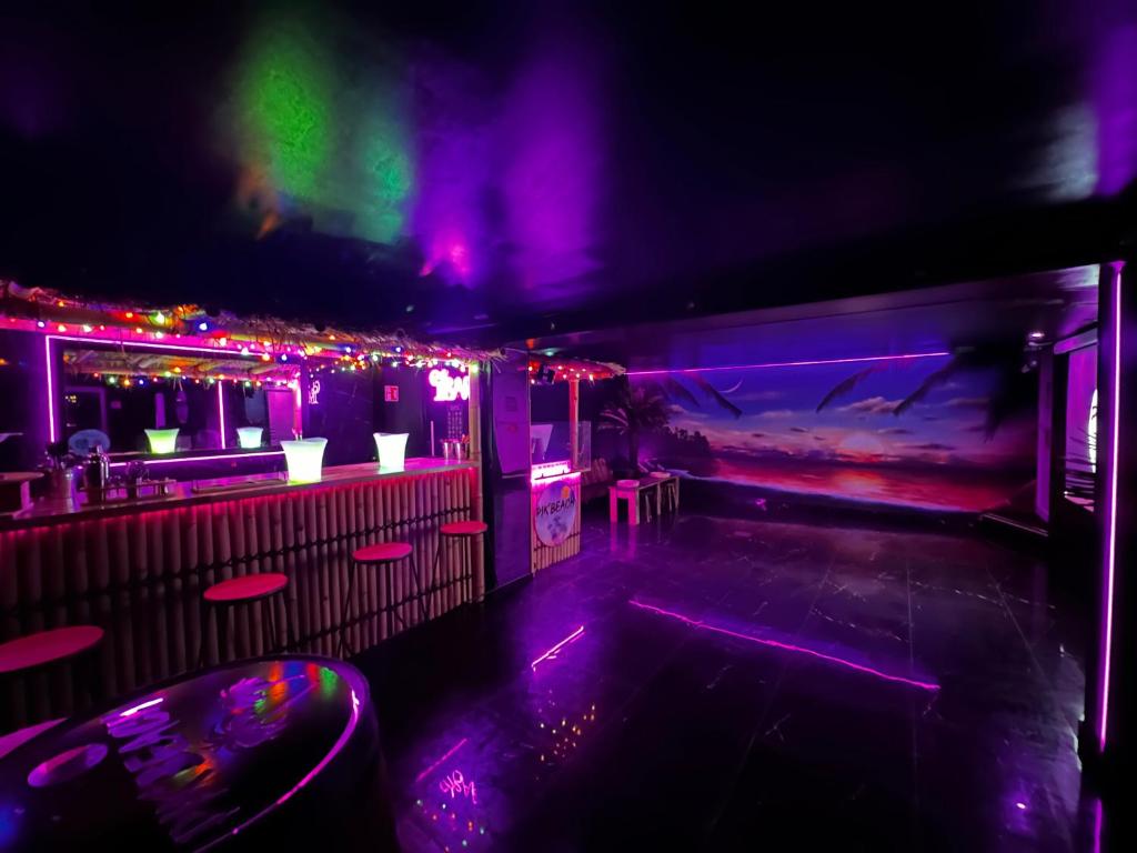 un club nocturno vacío con luces moradas y verdes en PikBeach77, en Saint-Fargeau-Ponthierry