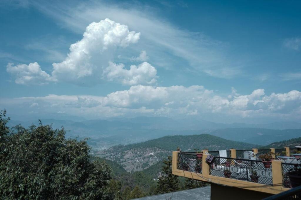 a balcony with a view of a city at Himalaya Mount View Resort Kausani in Kausani