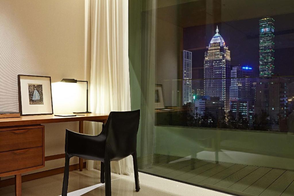 a desk and chair in a room with a window at Eslite Hotel in Taipei