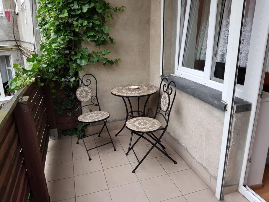 a table and two chairs sitting on a balcony at Noc w Centrum Apartament in Koszalin