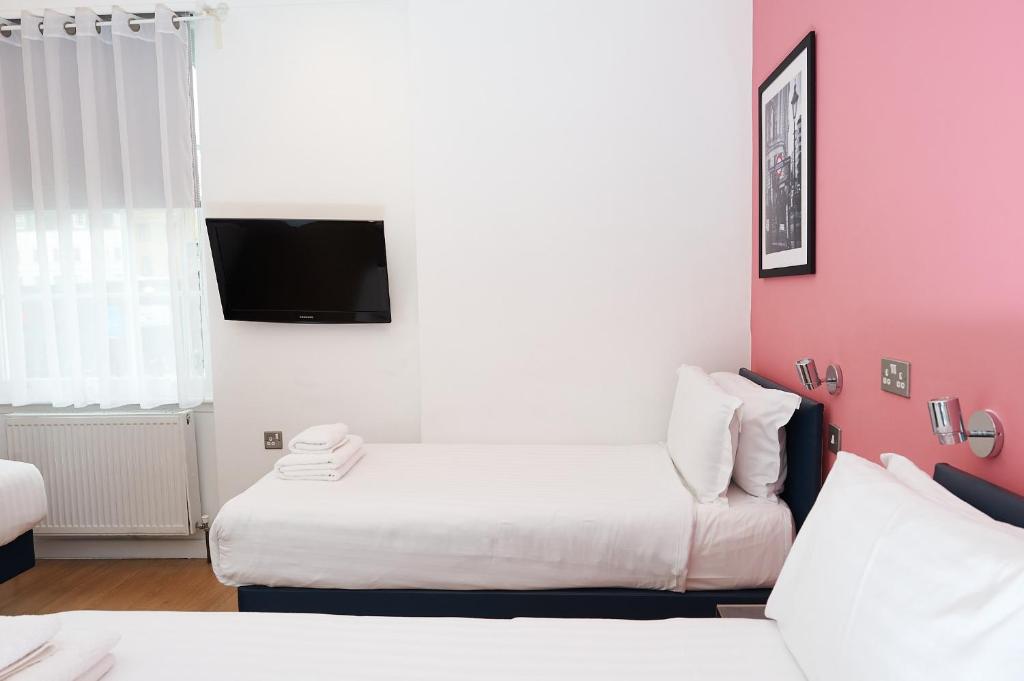 a hotel room with a bed and a tv at The California - London Kings Cross in London