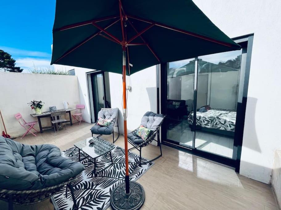 馬賽的住宿－Le Berceau Vert，庭院配有两把椅子和一把遮阳伞