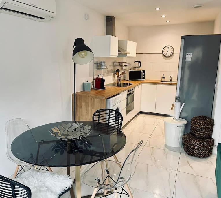 a kitchen with a glass table and chairs in a room at Le Berceau Vert in Marseille