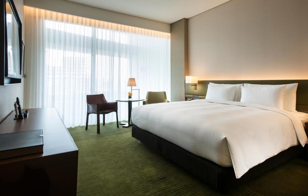 a hotel room with a large bed and a desk at Eslite Hotel in Taipei