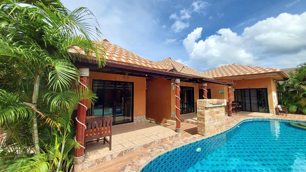 a house with a swimming pool in front of a house at Panisara Pool Villa Resort Huahin in Hua Hin