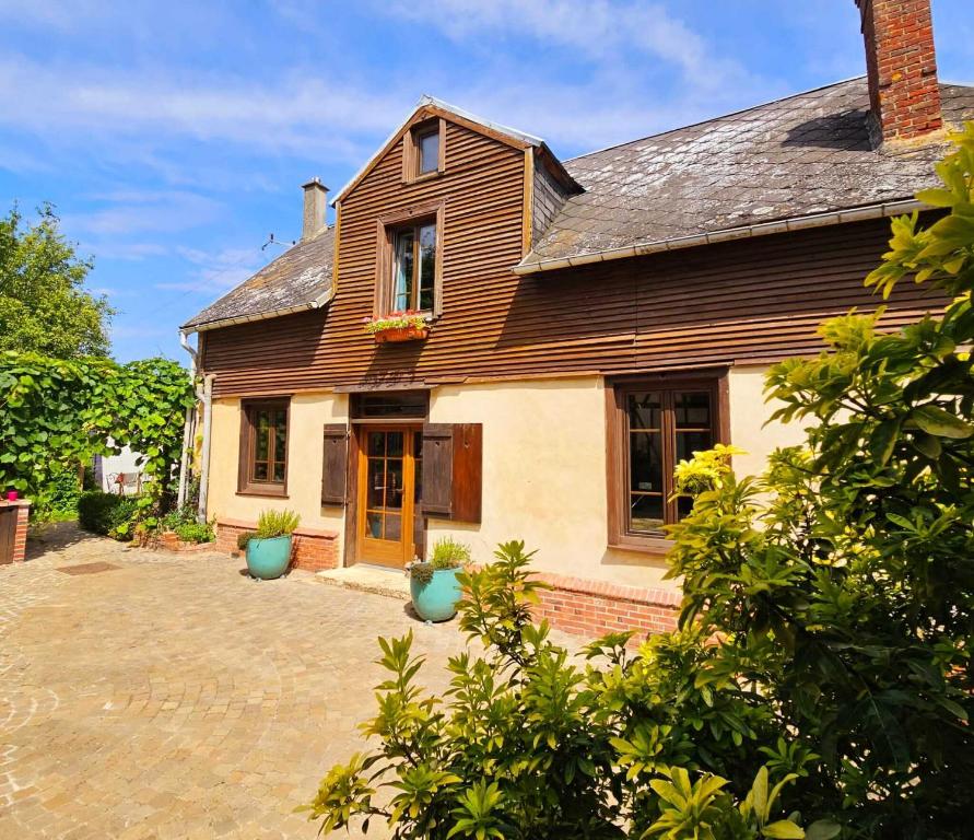 a house with two blue vases in front of it at Au Refuge Des 3 Ours - Chambres d&#39;hôtes et cabanes in Essuiles-Saint-Rimault