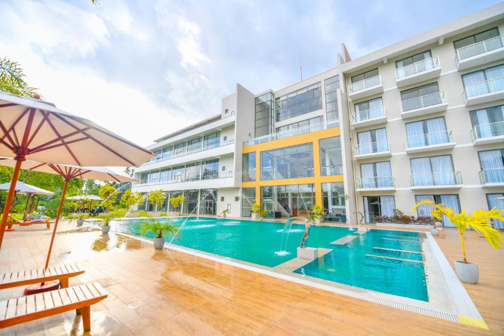 uma piscina em frente a um edifício em Oasis Riverside Hotel em Kalutara