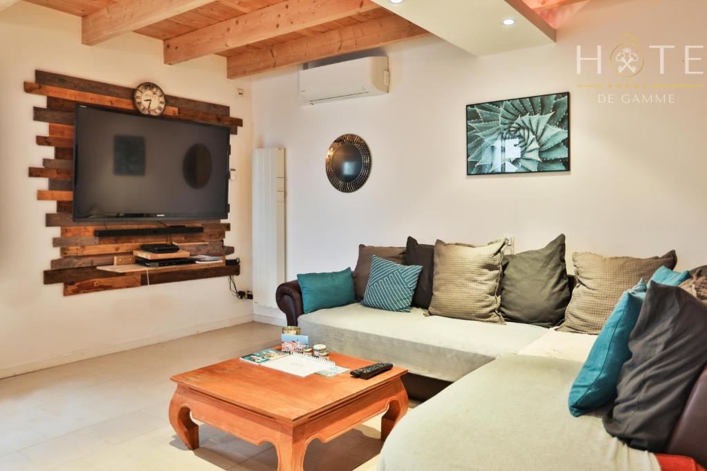 ein Wohnzimmer mit einem Sofa und einem TV in der Unterkunft L'Airial - Maison idéalement située entre commerces et plage in Olonne-sur-Mer